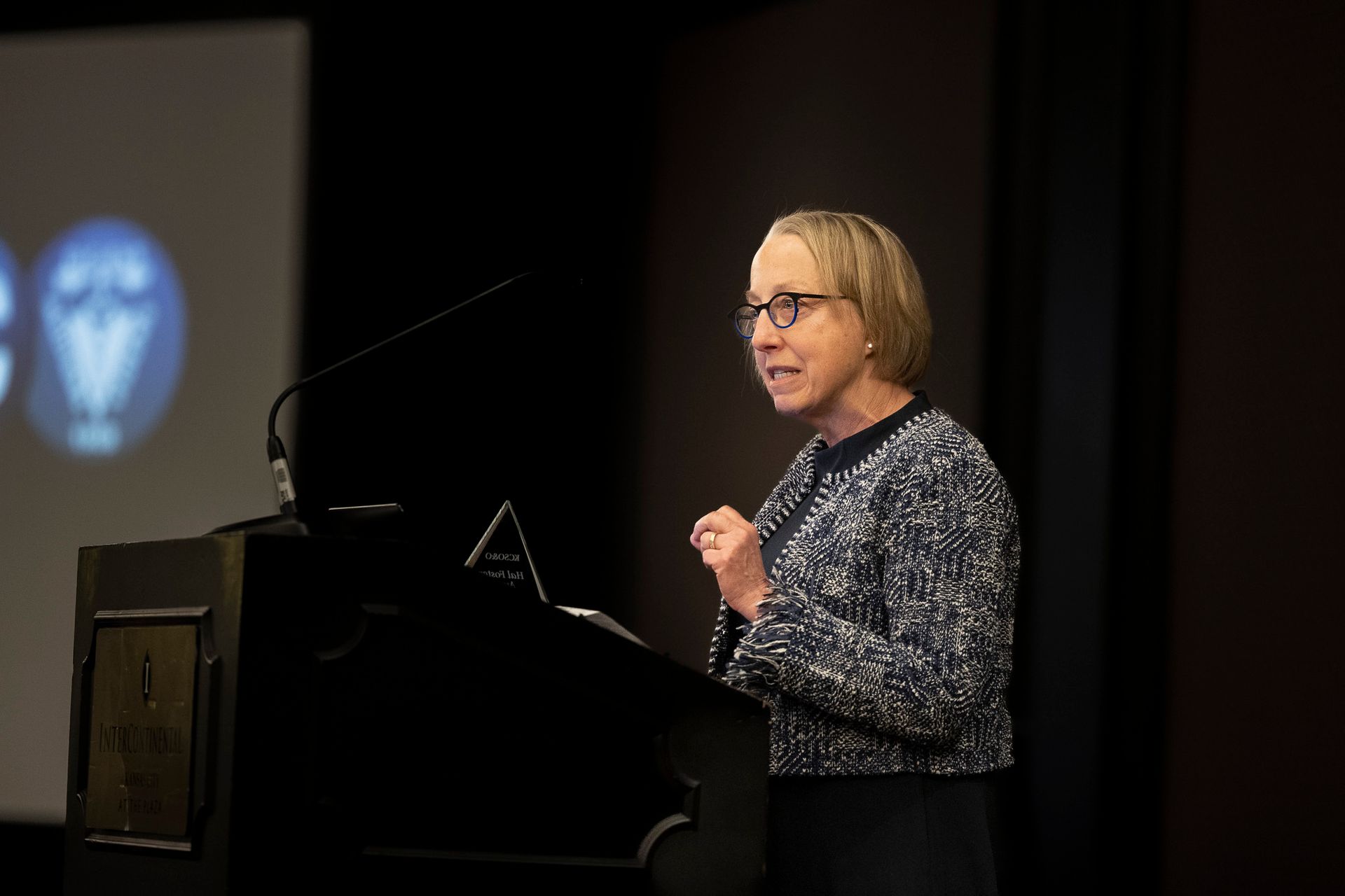 A woman is standing at a podium giving a speech.