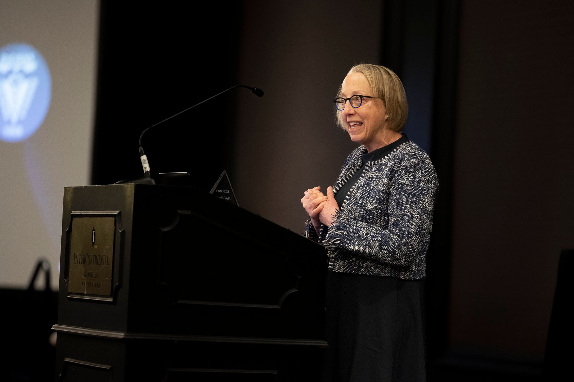 A woman is standing at a podium giving a presentation.