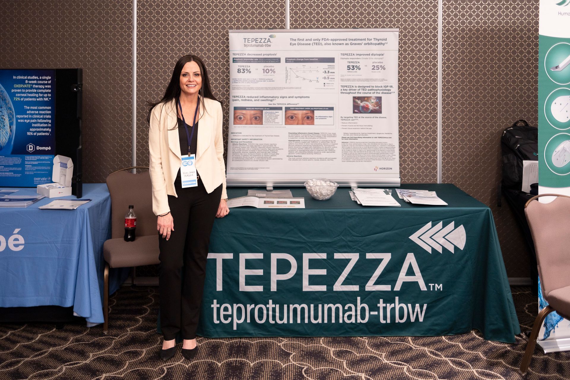 A woman stands in front of a table that says tepezza