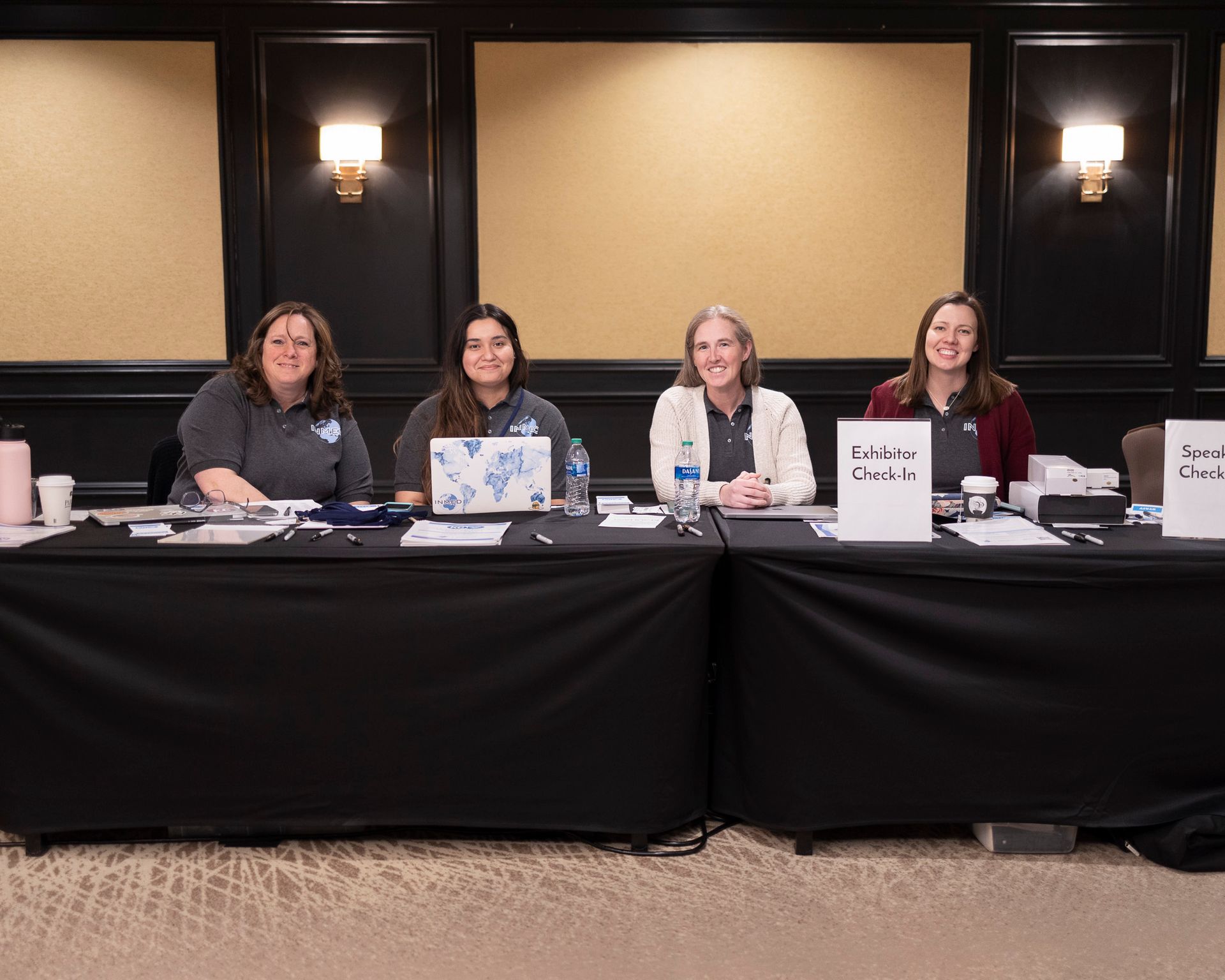A group of women are sitting at a long table.