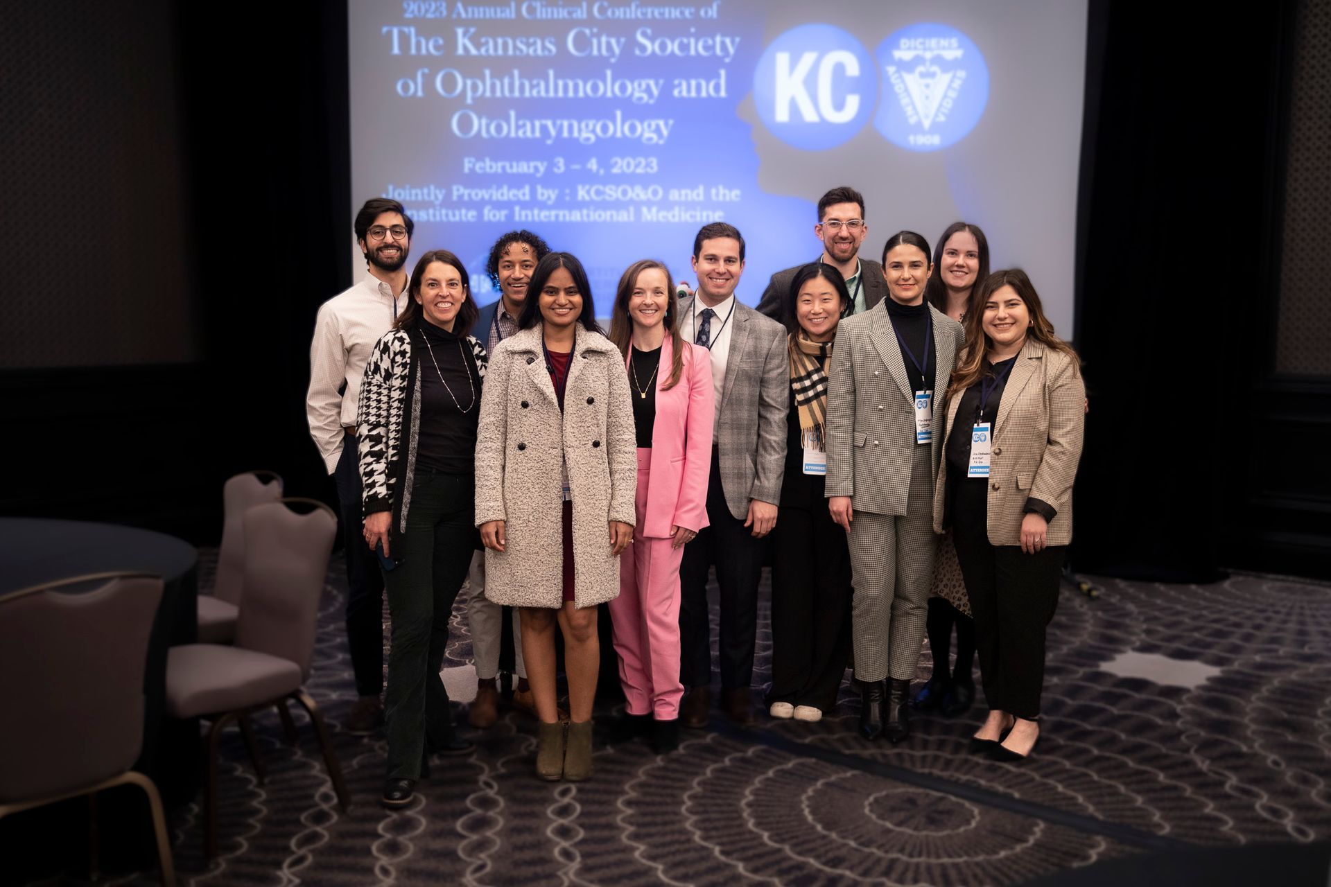 A group of people are posing for a picture at a conference.