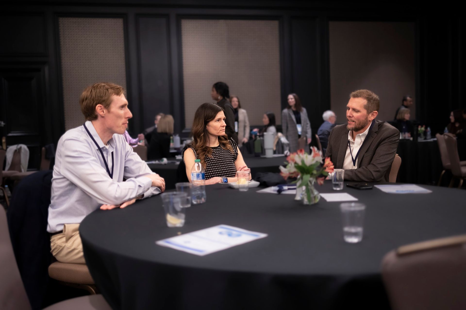 A group of people are sitting at a table talking to each other.