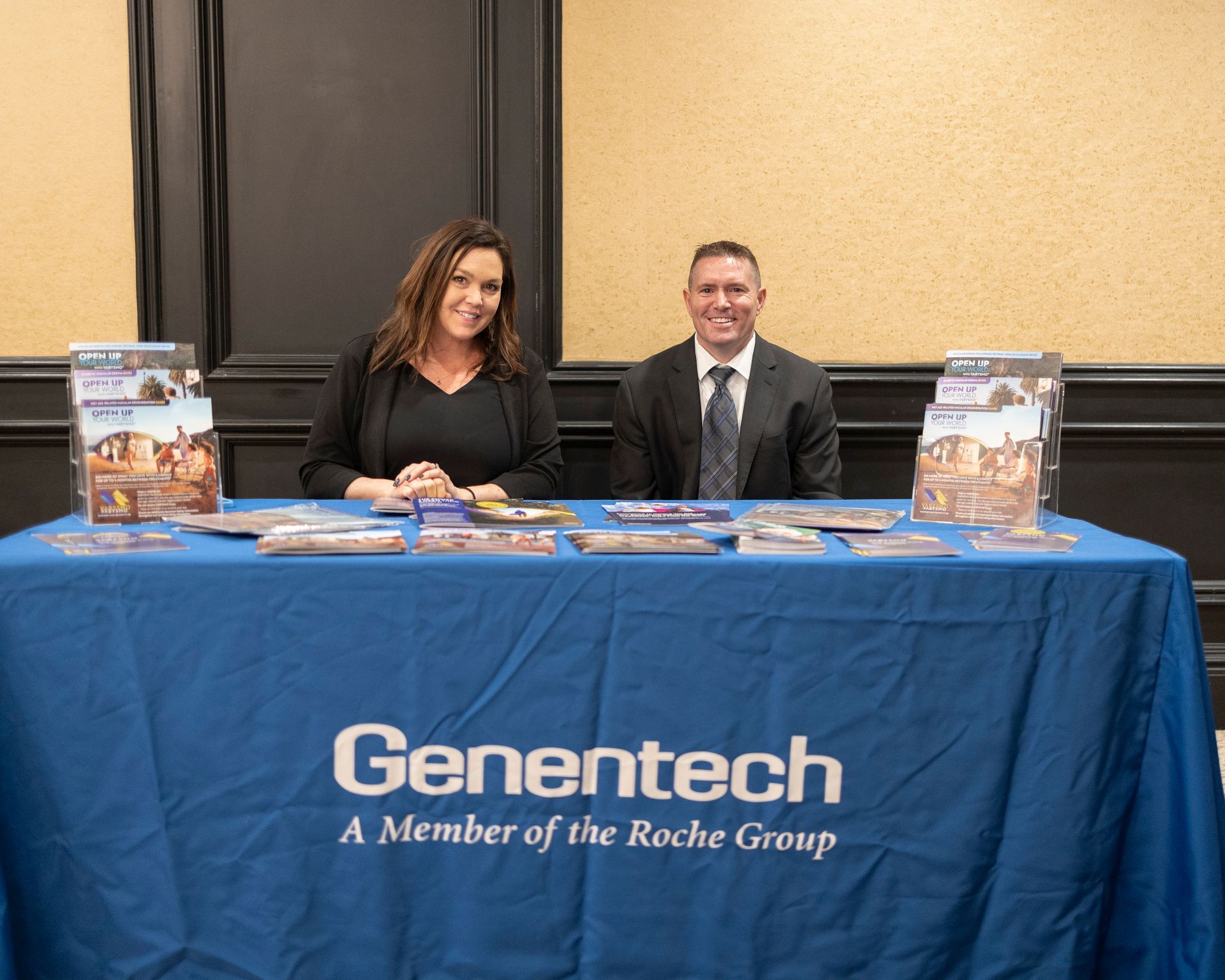 A man and a woman are sitting at a genetech table.
