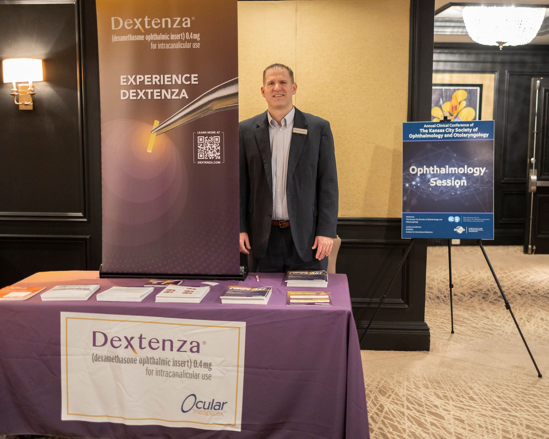 A man standing in front of a table with a sign that says dextenza