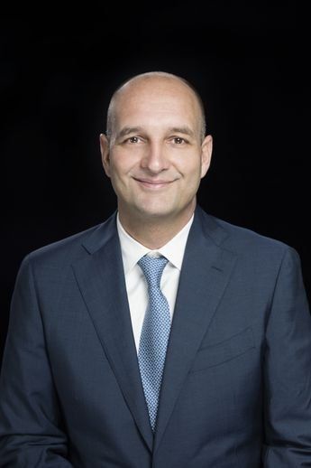 A man in a suit and tie is smiling for the camera.