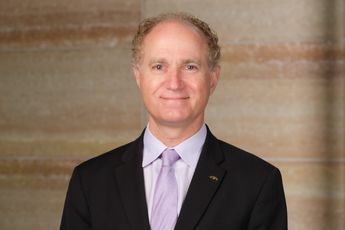 A man in a suit and tie is smiling for the camera.