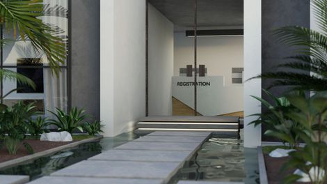 Esterno di un edificio moderno con giochi d'acqua e passerella che conduce all'ingresso.