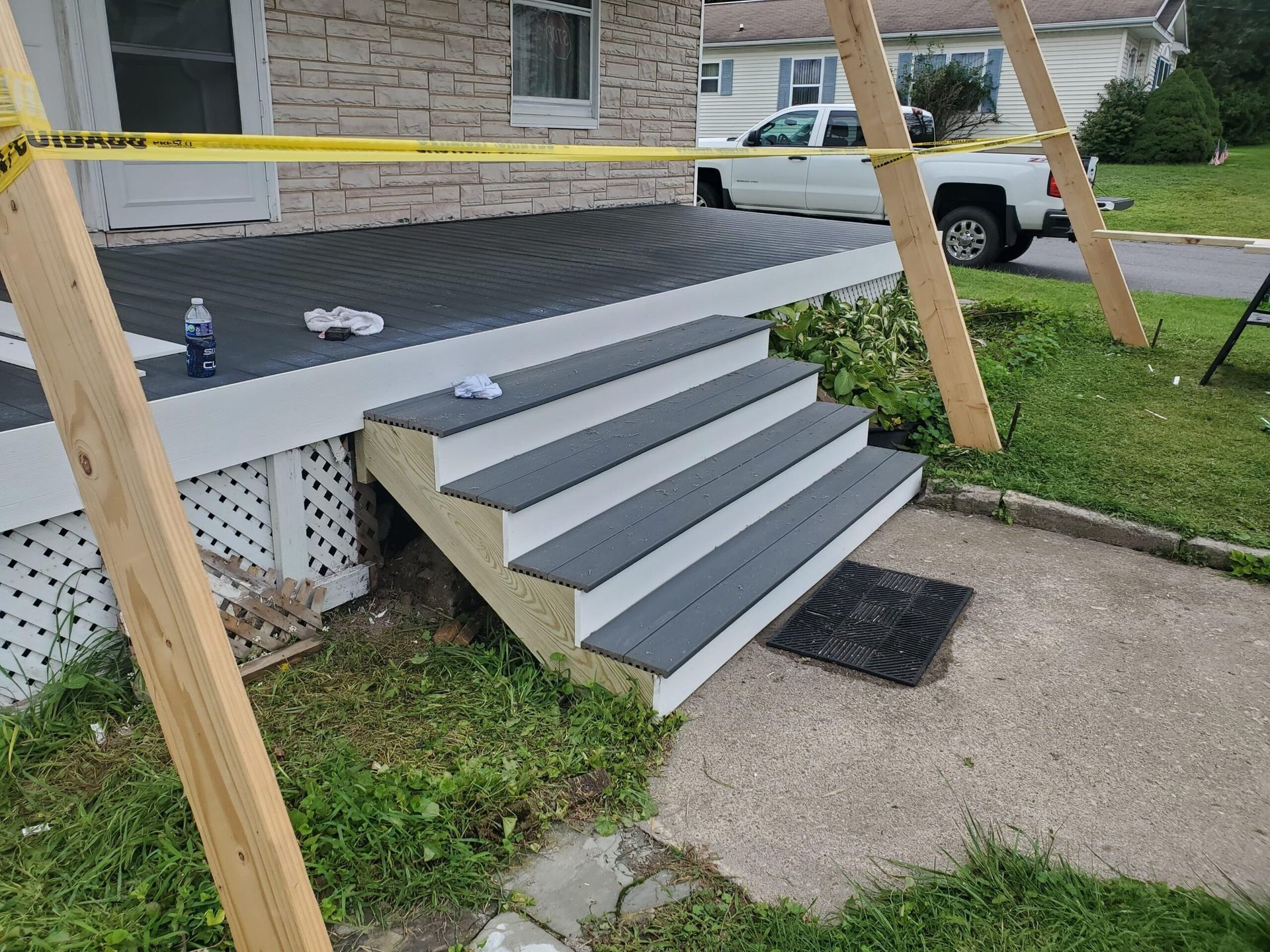 Newly built porch steps and deck with support beams and caution tape.