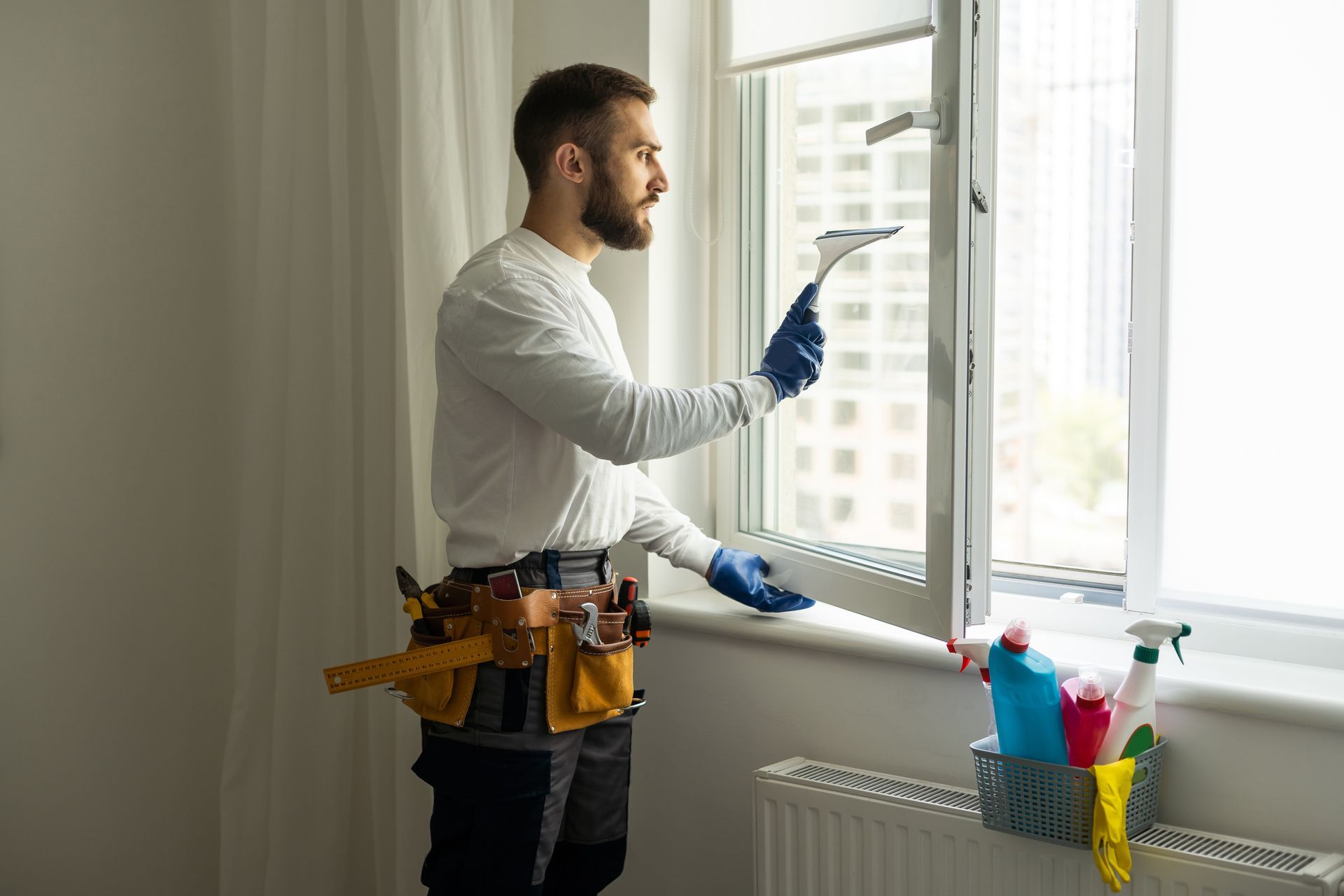 Young man washing window in home