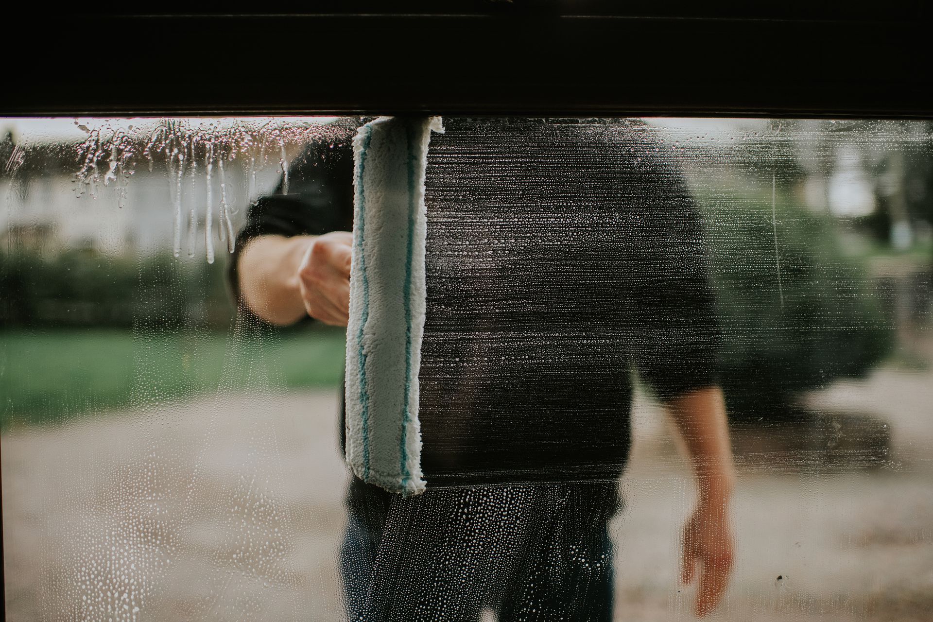 Close-up of a man cleaning windows with a squeegee