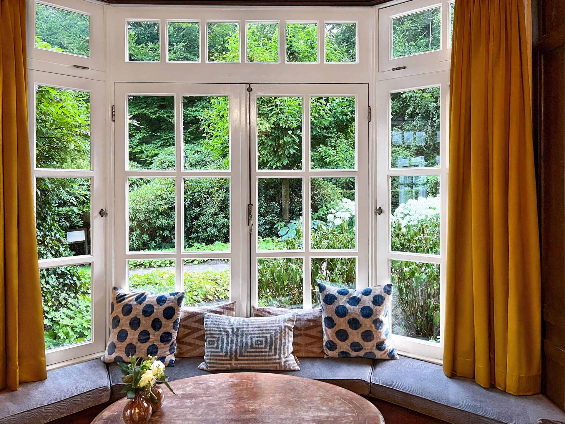 A living room with a large window and a table in front of it.