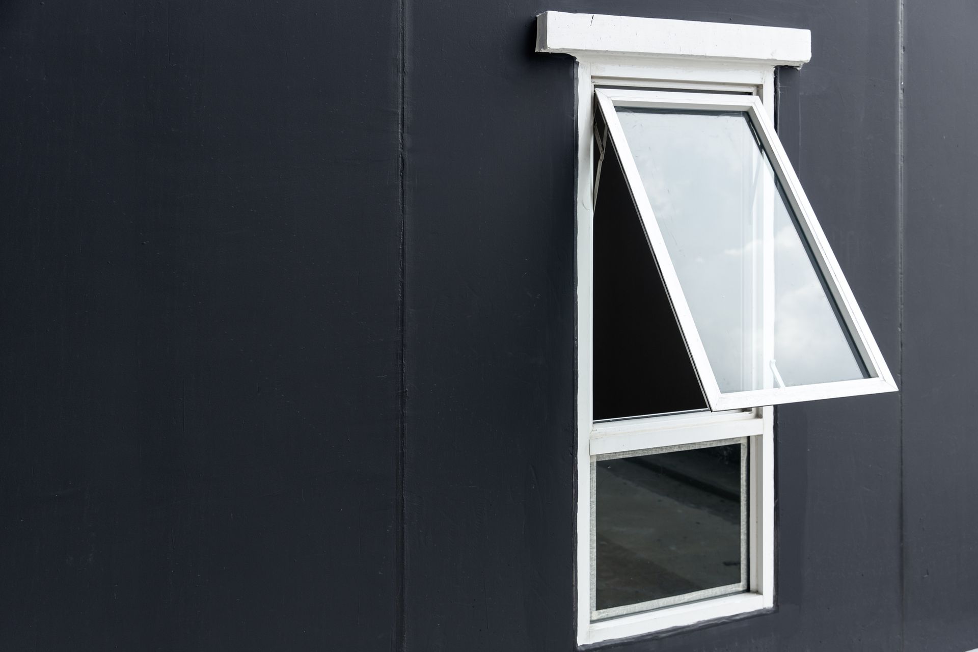 A white window is open on a black wall.