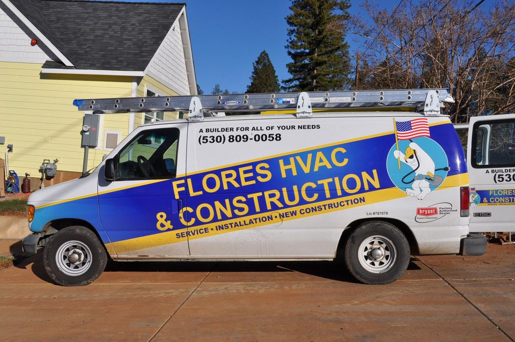 Flores HVAC & Construction service van parked beside a house on a sunny day