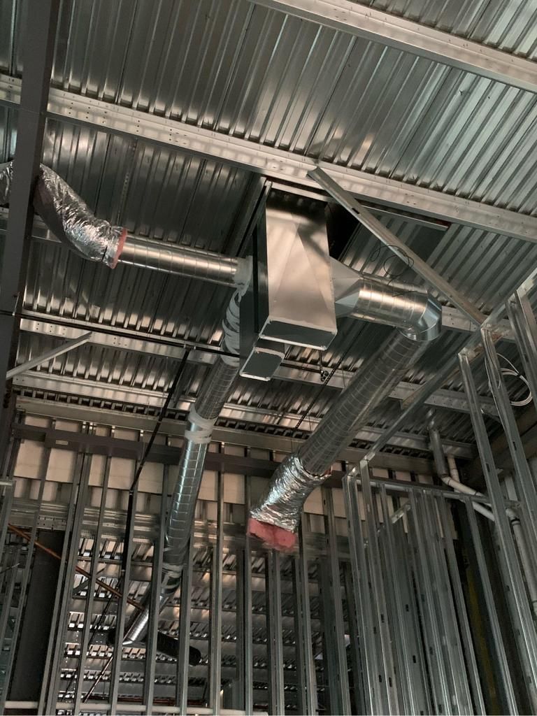 A ceiling with a lot of pipes coming out of it.