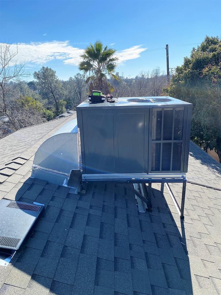 An air conditioner is sitting on top of a roof.