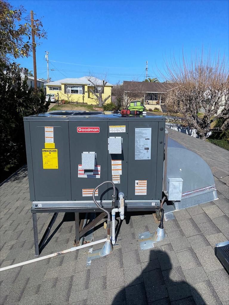 A large air conditioner is sitting on top of a roof.