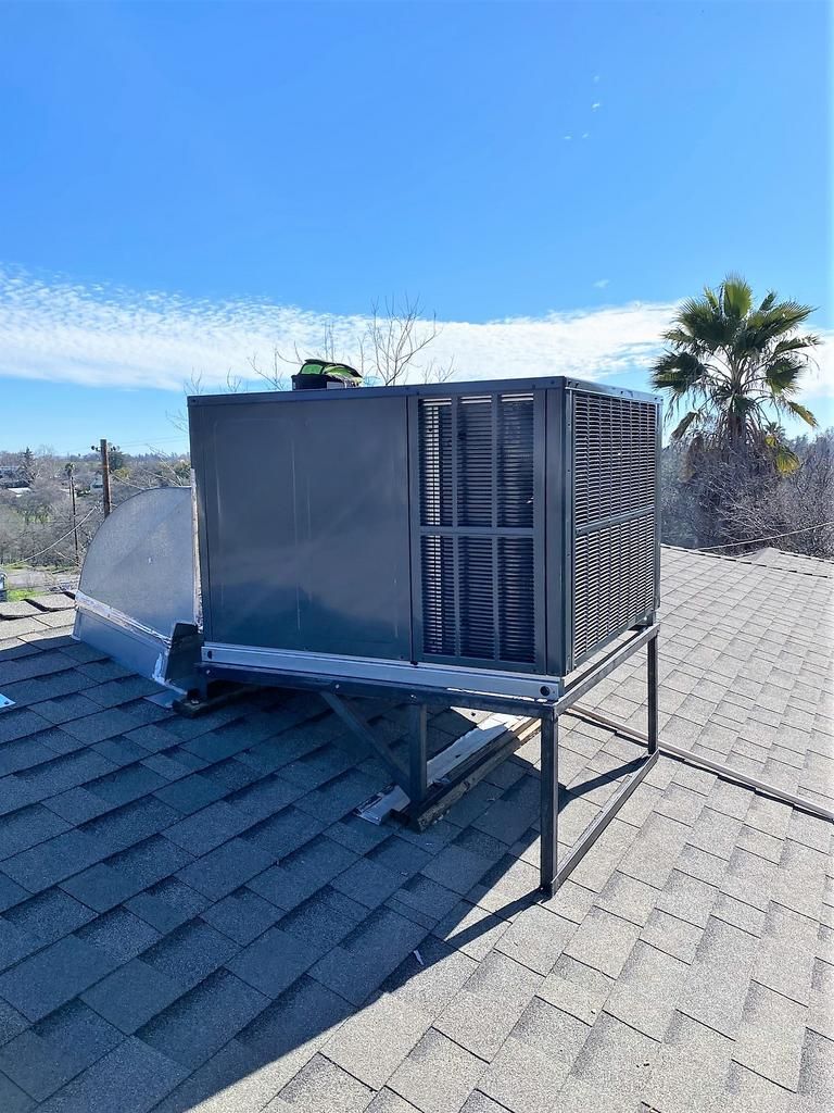 A large air conditioner is sitting on top of a roof.