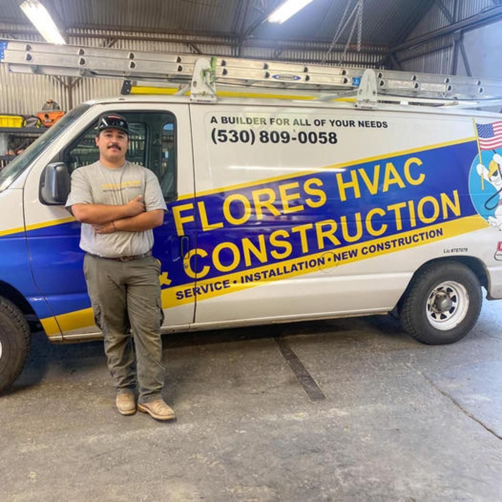 A man is standing in front of a flores hvac construction van