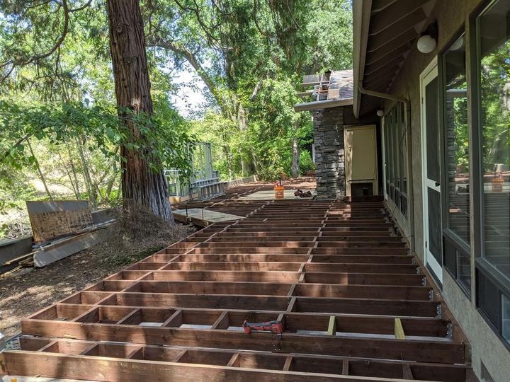 A wooden deck is being built on the side of a house.