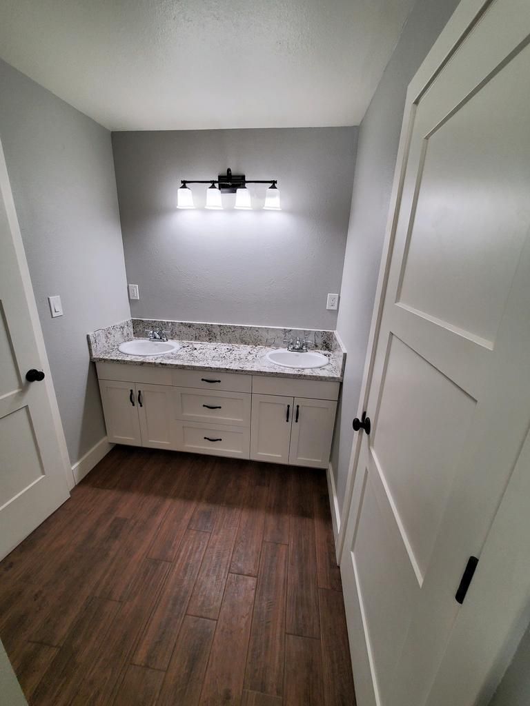 A bathroom with two sinks and a light on the wall.