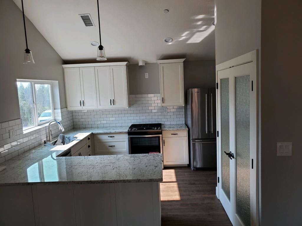 A kitchen with white cabinets and stainless steel appliances