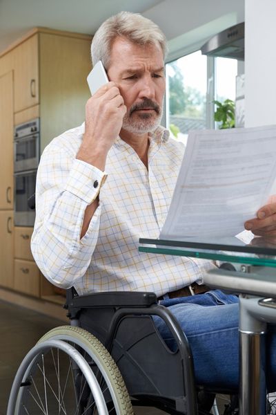 Frustrated Man In Wheelchair Making Phone — Troy, Oh — Shipman Dixon & Livingston Lpa Attorneys at Law