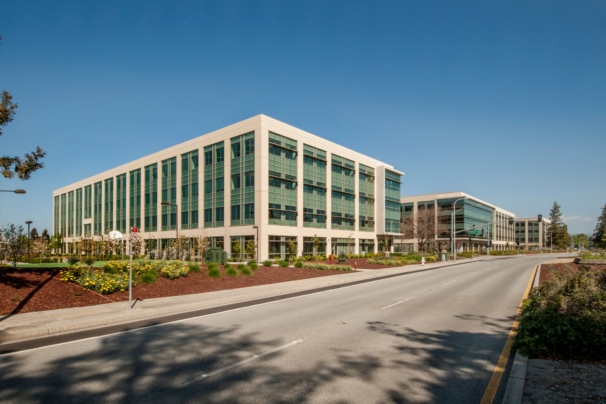 A large building with a lot of windows is next to a road