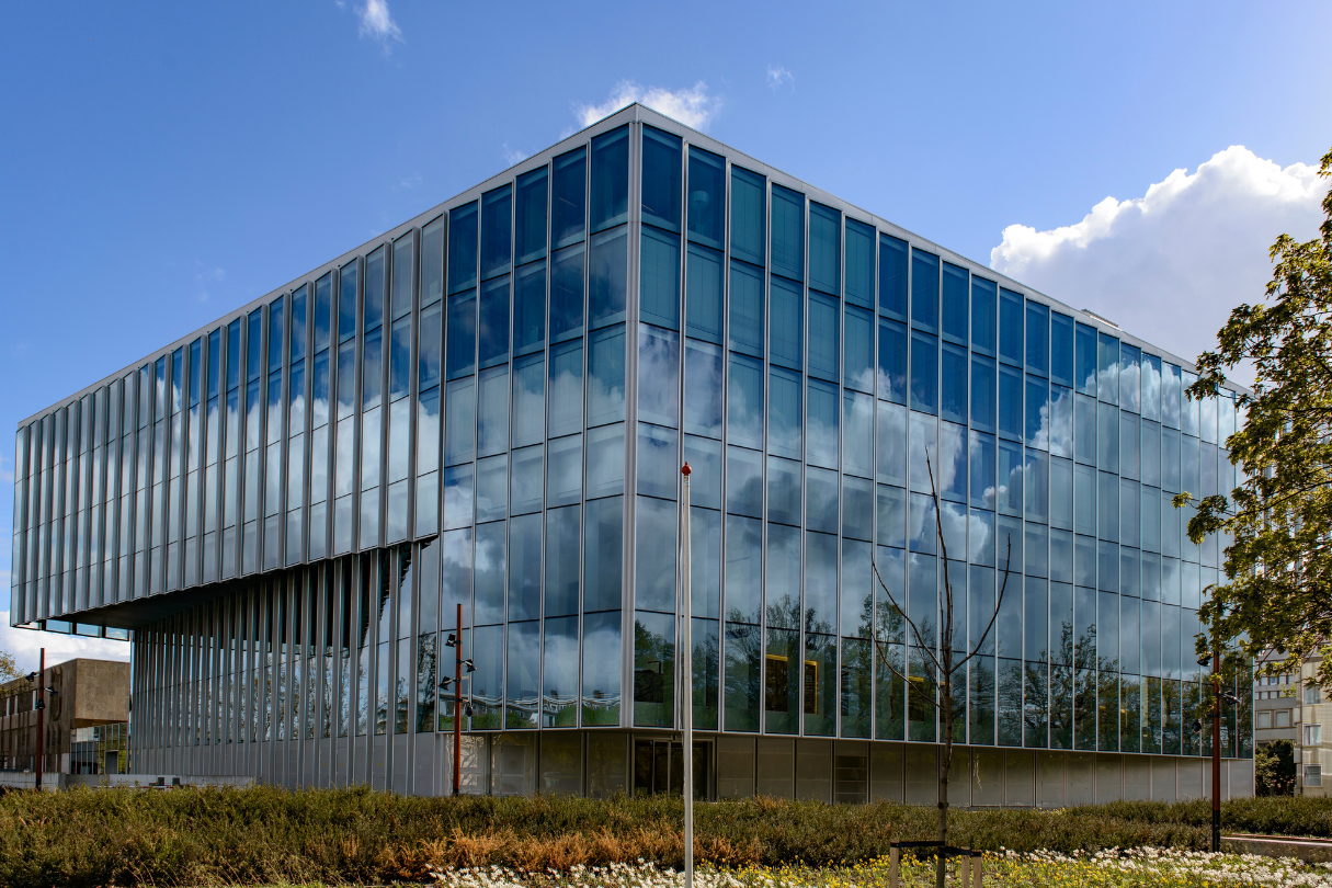 A large building with a lot of windows and trees in front of it