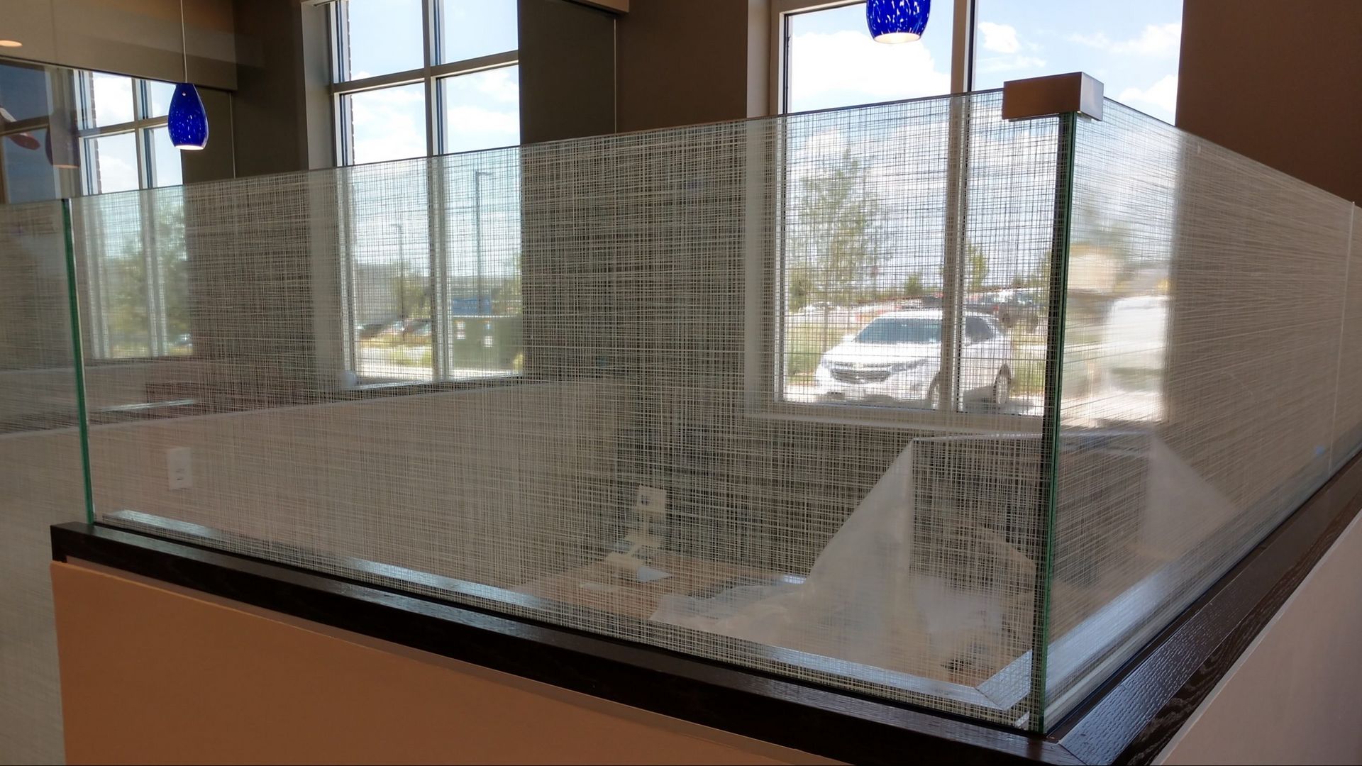 A glass wall with a window in a bathroom featuring privacy tint, located in San Antonio.