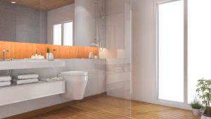 A bathroom with a toilet , sink , mirror and walk in shower.