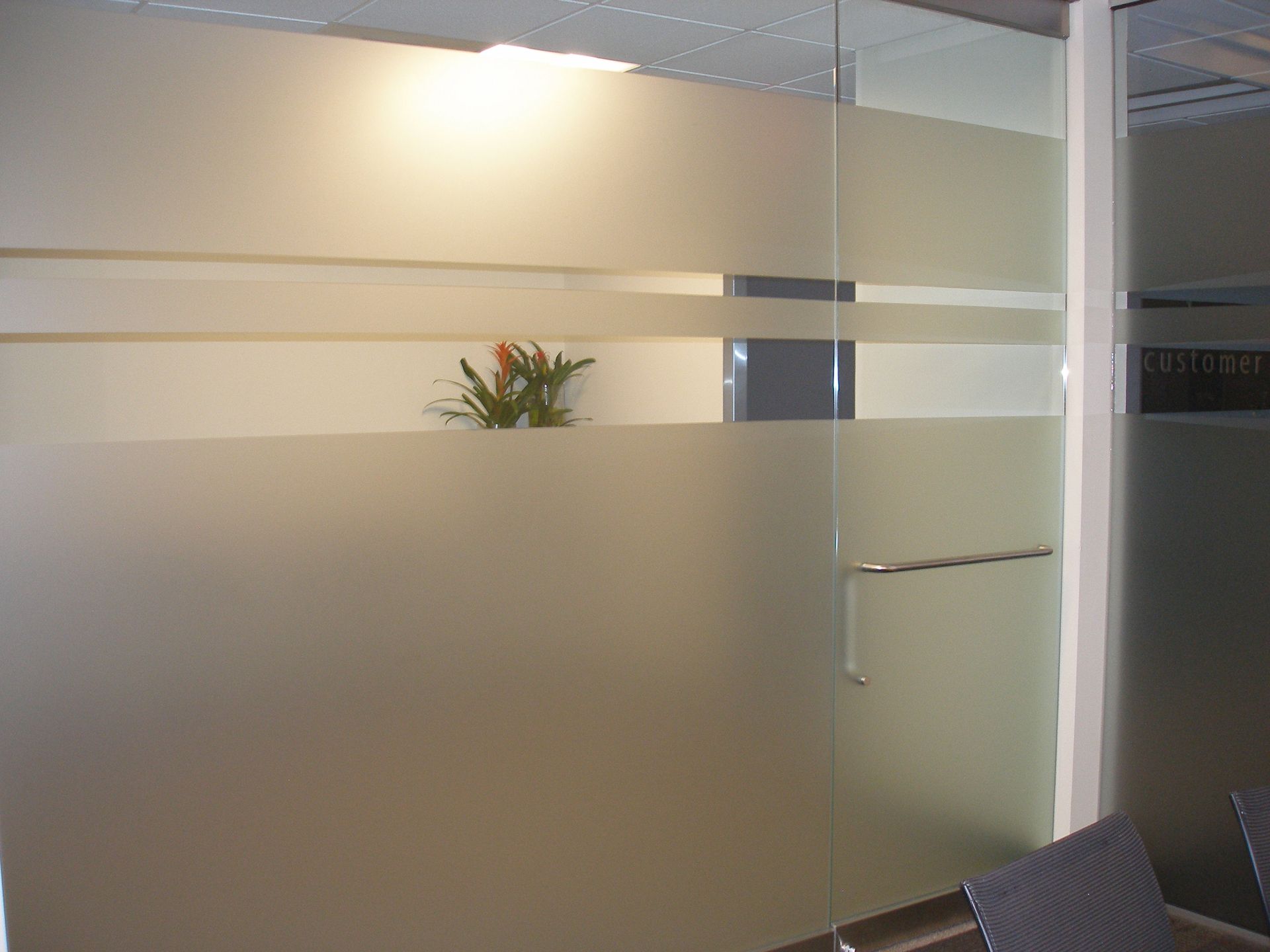 A man and a woman are sitting on a couch with their hands behind their heads.