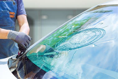 A woman is driving a car on a sunny day.