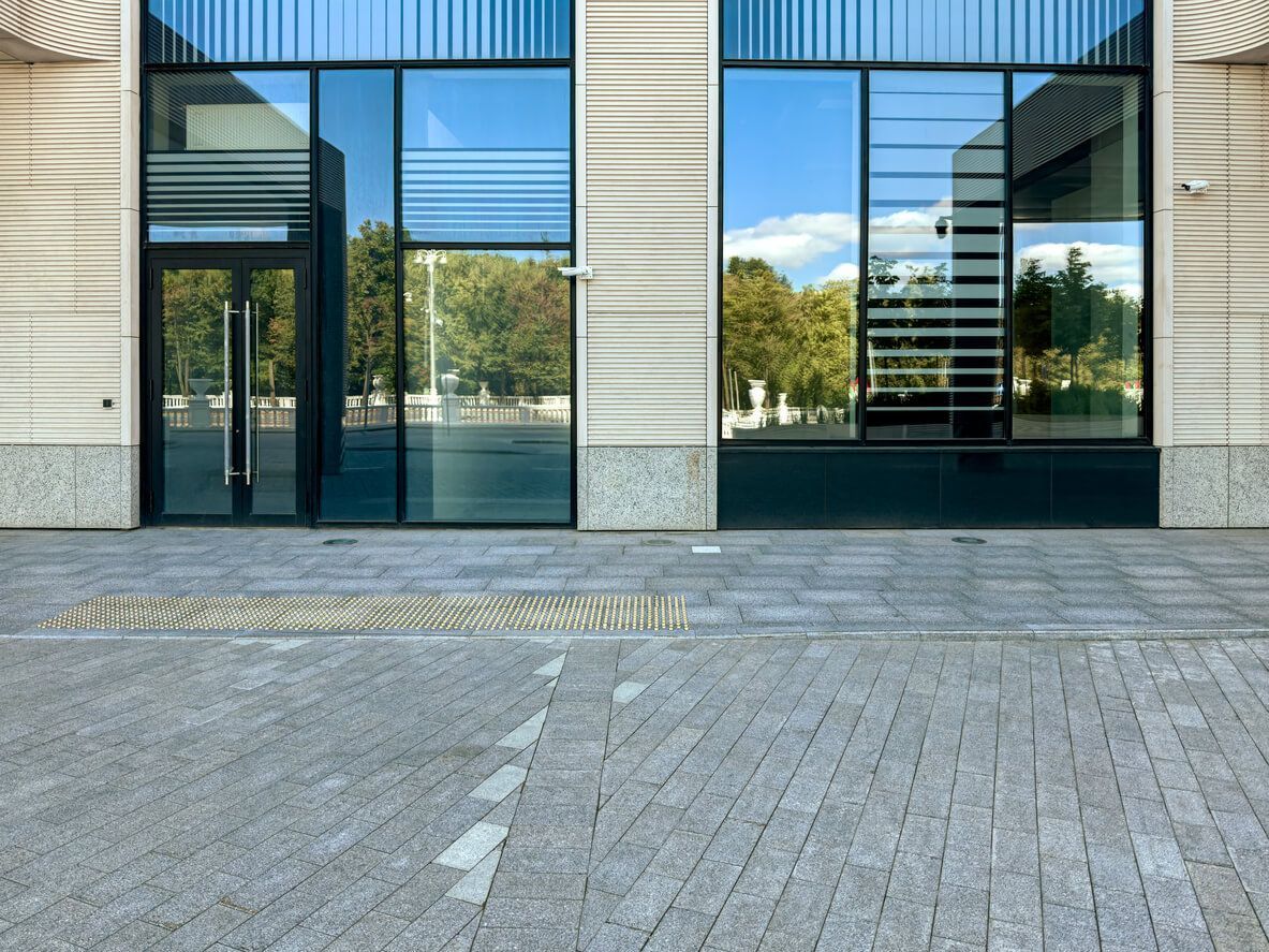 A man works on a car window, demonstrating a step in the window tint removal process.