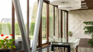 A dining room with a glass table and chairs and a lot of windows.