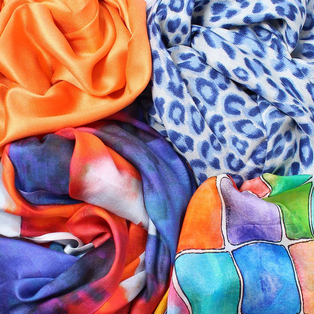 A bunch of colorful scarves are stacked on top of each other