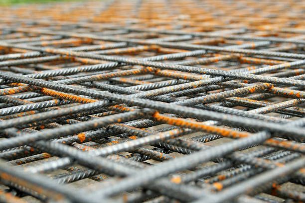 A close up of a metal mesh on a concrete surface.