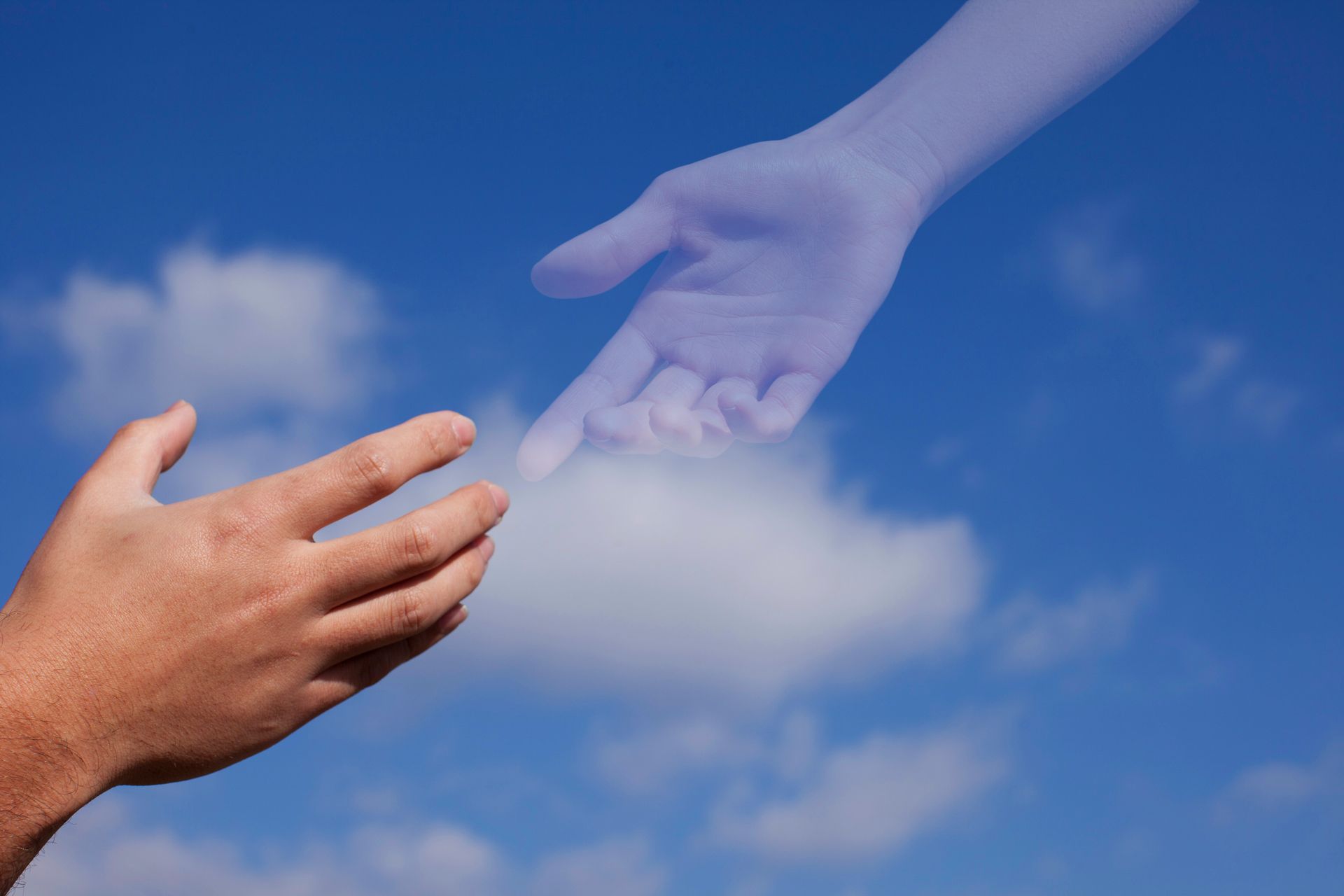 A hand reaching out towards another hand in the sky