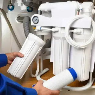Doctor Cool - A man in a blue shirt is working on a water filter