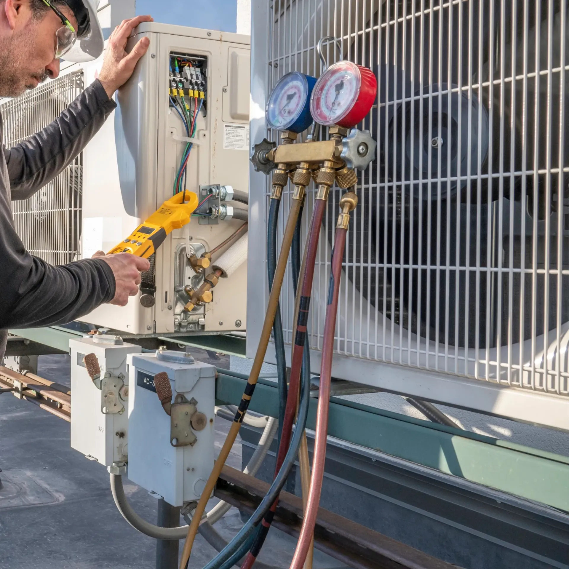 Doctor Cool - A man is working on an air conditioner with a pair of pliers