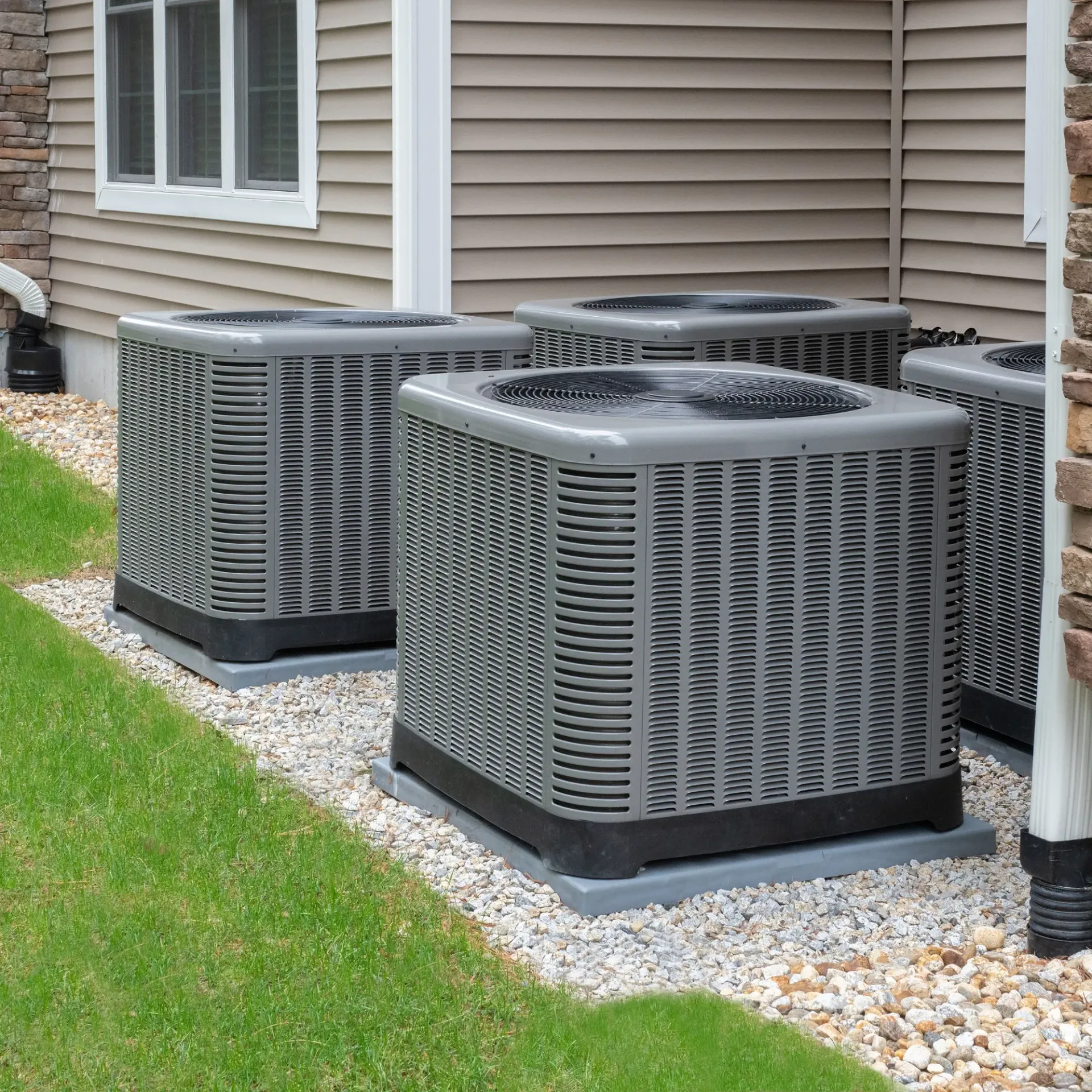 Doctor Cool - A row of air conditioners are sitting outside of a house
