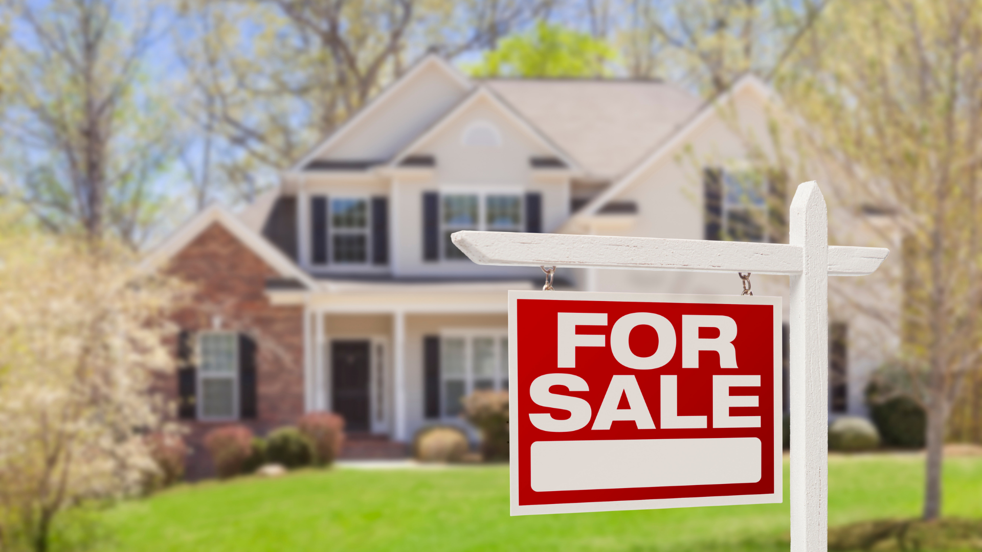 A for sale sign is in front of a house.