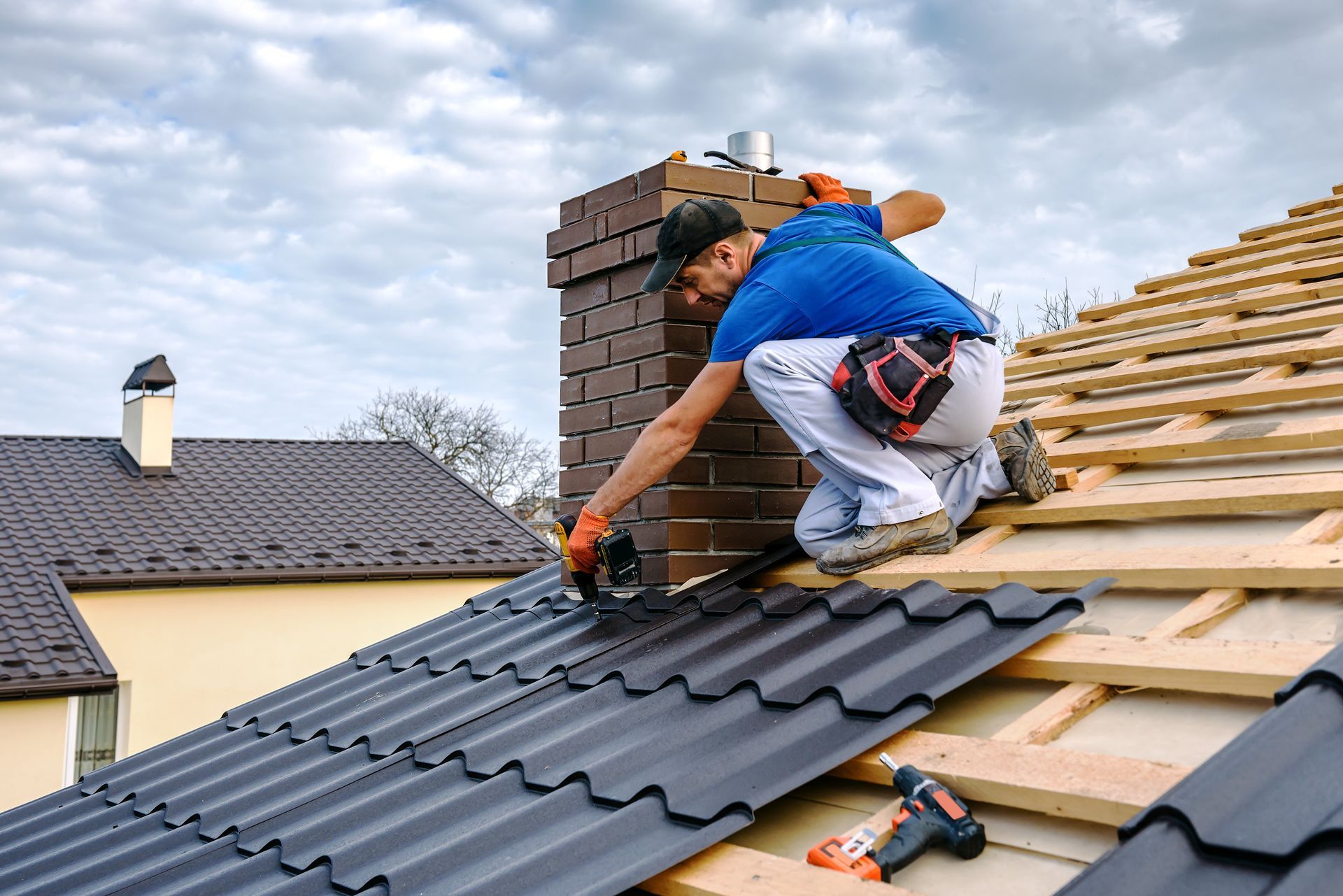 A local roofing contractor, wearing a blue shirt, is performing an installation.
