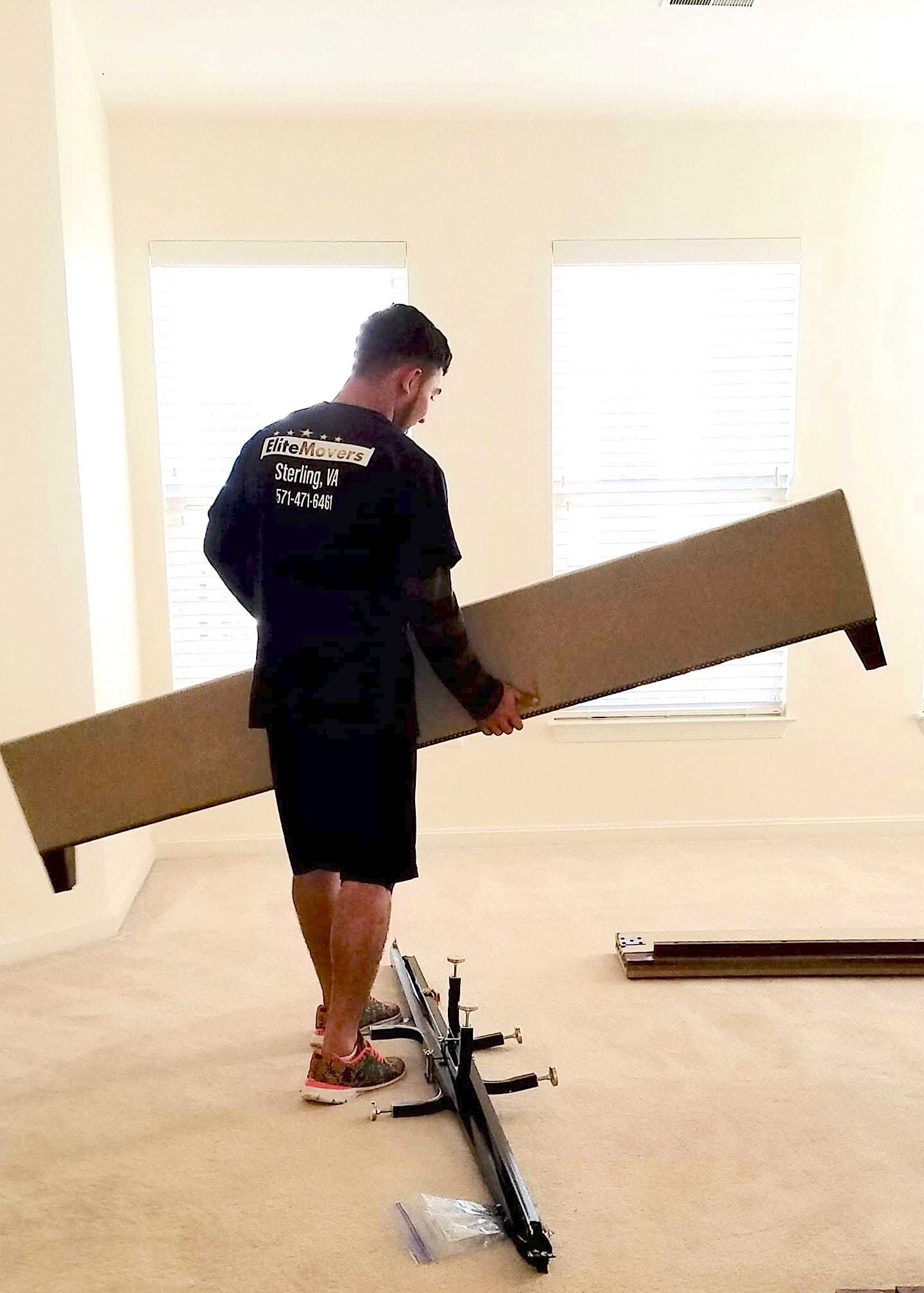 Elite mover employee holding a wooden board