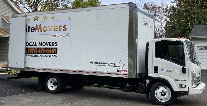 A white item movers truck is parked in front of a house