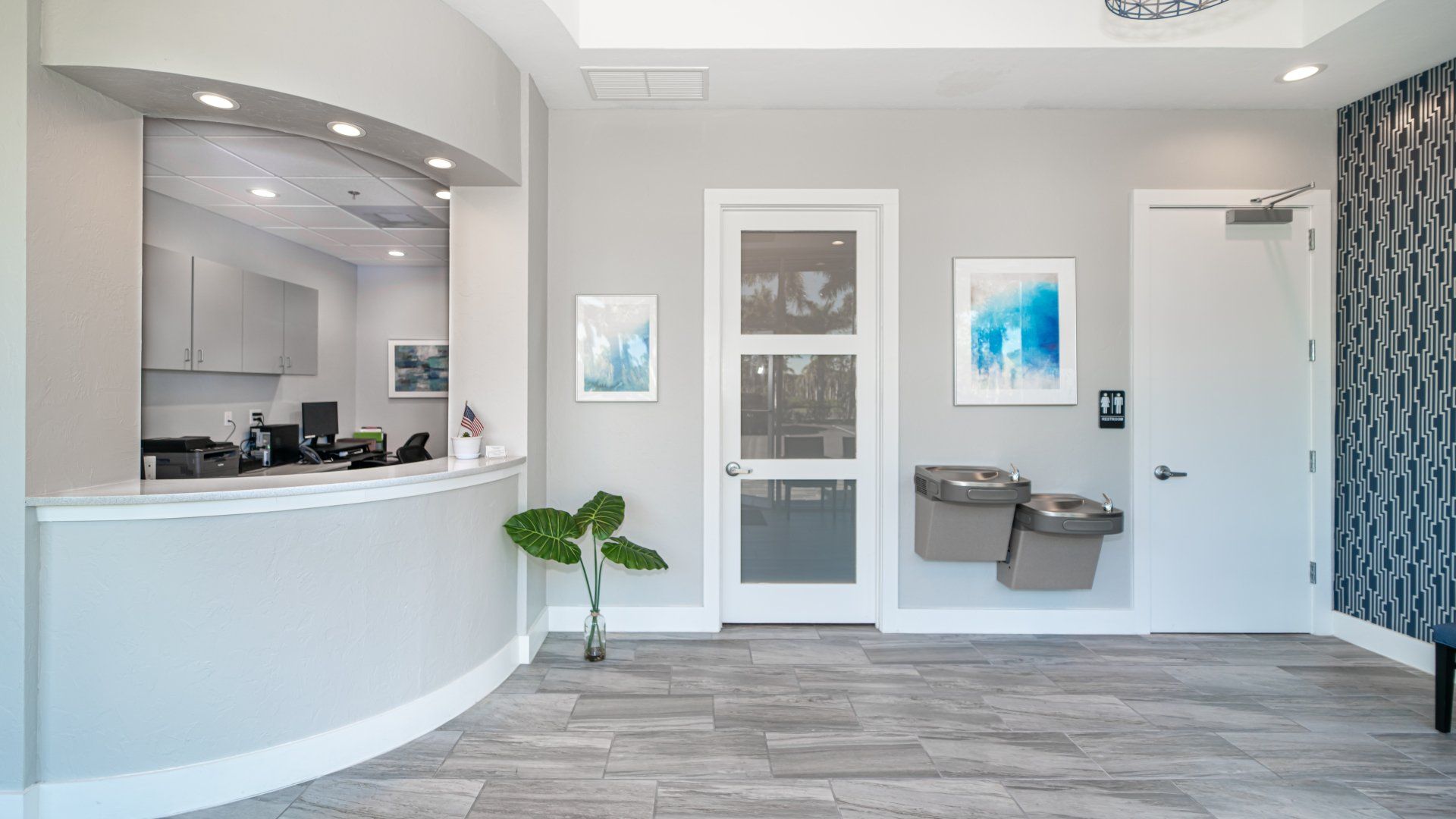 A dental office with a reception desk and a water fountain.