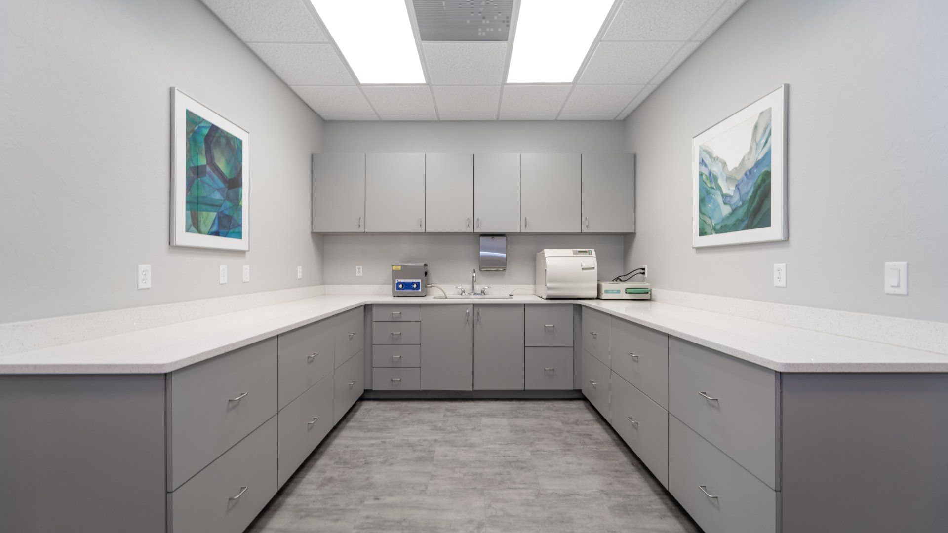 A room with a lot of cabinets and drawers and a painting on the wall.