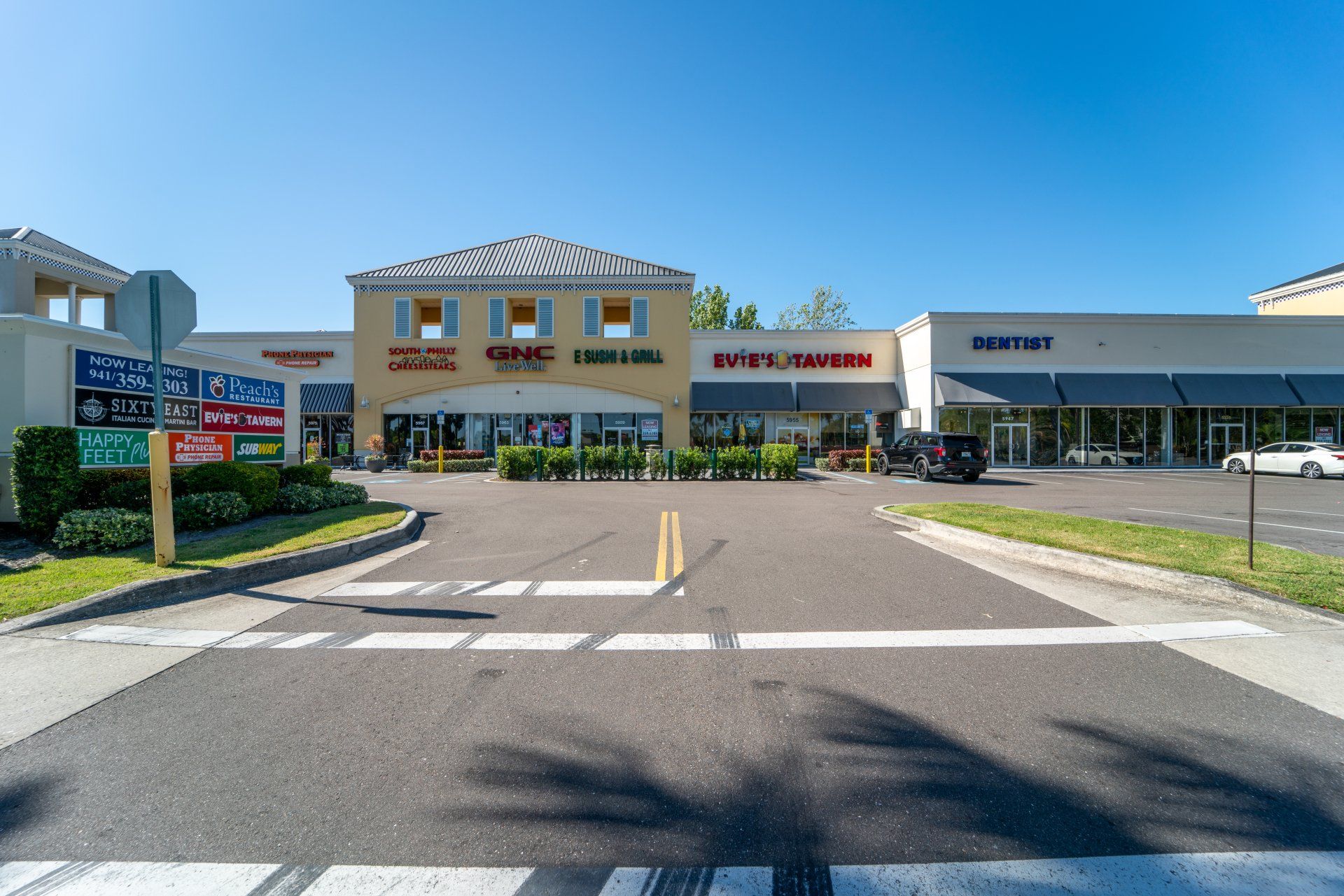 There is a crosswalk in front of a shopping center.