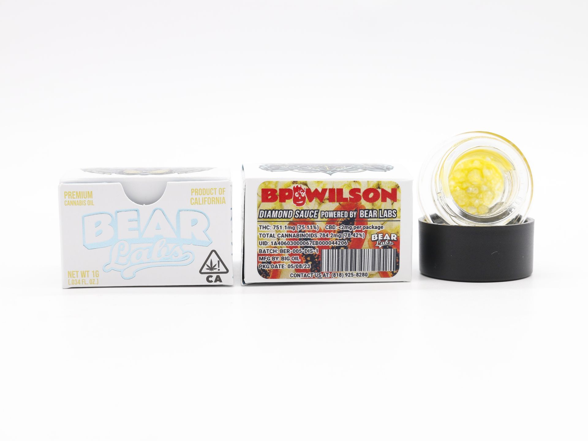 A box of gear wax next to a glass container on a white surface.