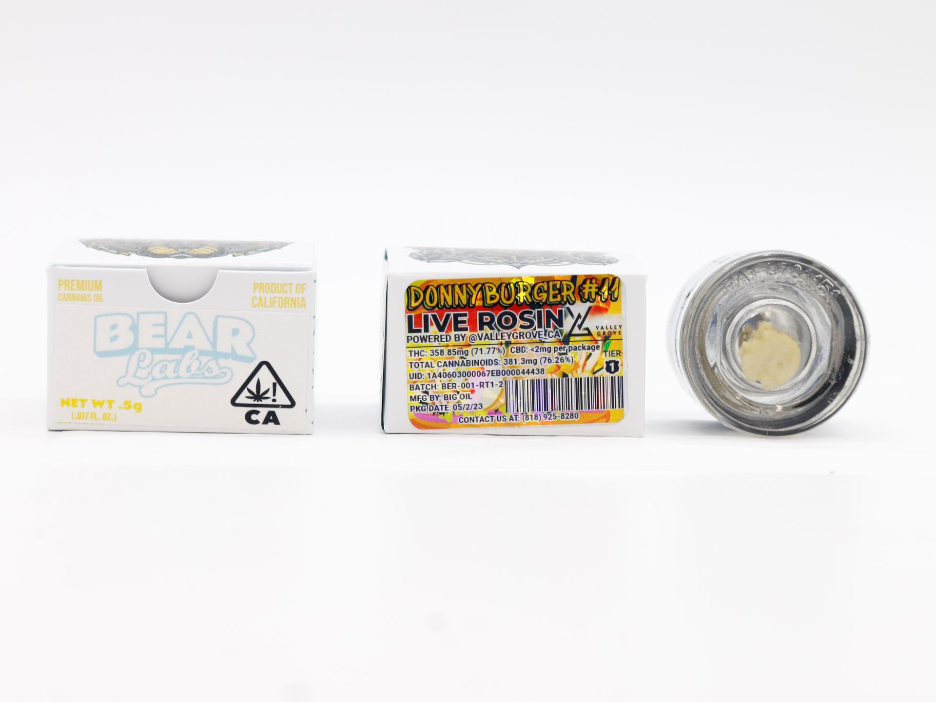 A jar of live rosin next to a box on a white surface.