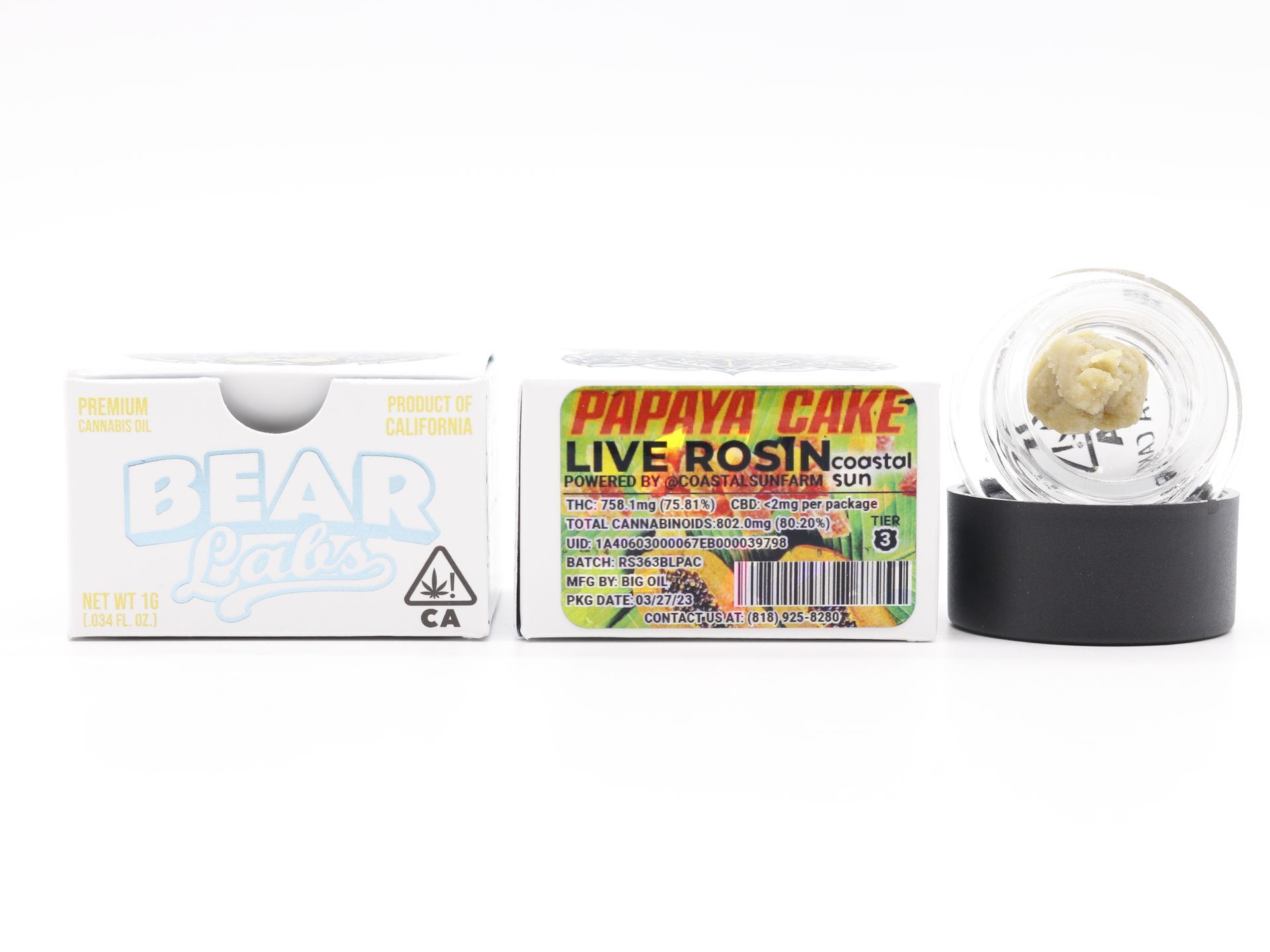 A box of papaya cake live rosin next to a snow globe.